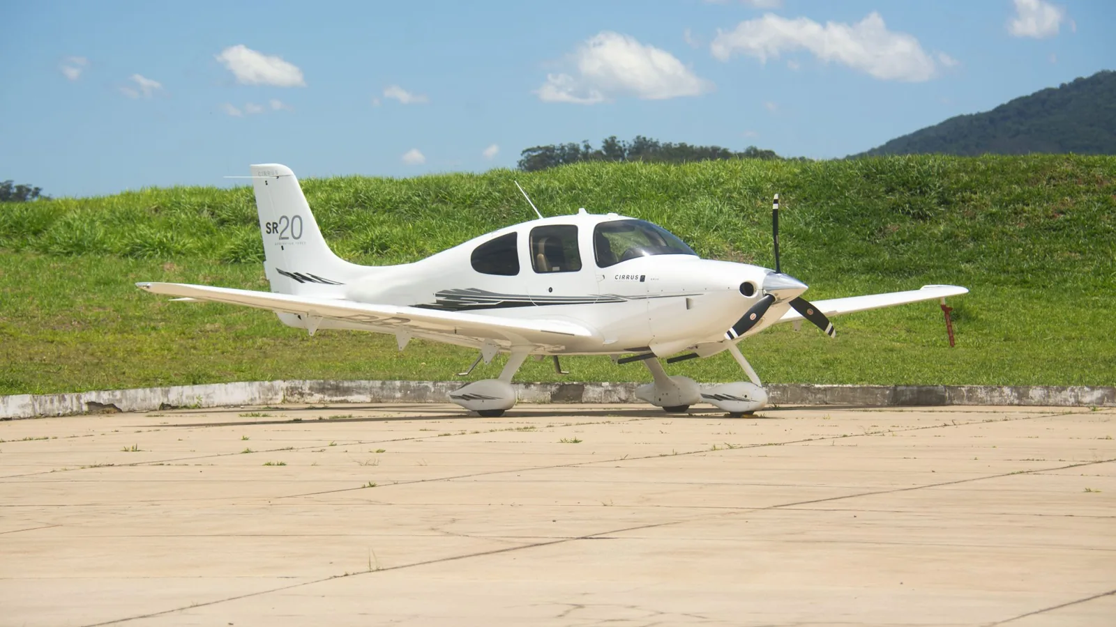 Cirrus SR20 2008 do anúncio da CFLY, visto de lado no pátio